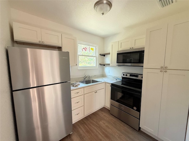 kitchen featuring white cabinetry, sink, dark hardwood / wood-style floors, and appliances with stainless steel finishes