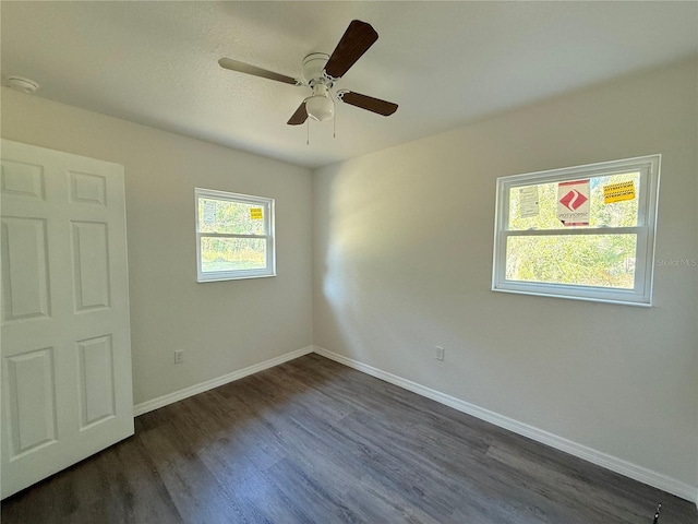 empty room with dark hardwood / wood-style flooring and ceiling fan