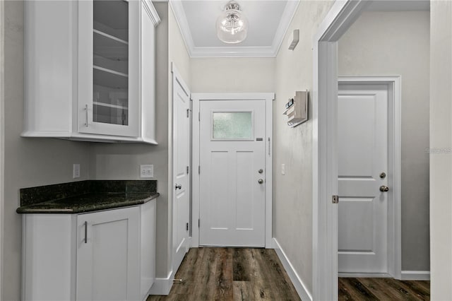 doorway with dark hardwood / wood-style flooring and ornamental molding