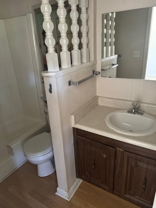 bathroom with hardwood / wood-style floors, vanity, and toilet