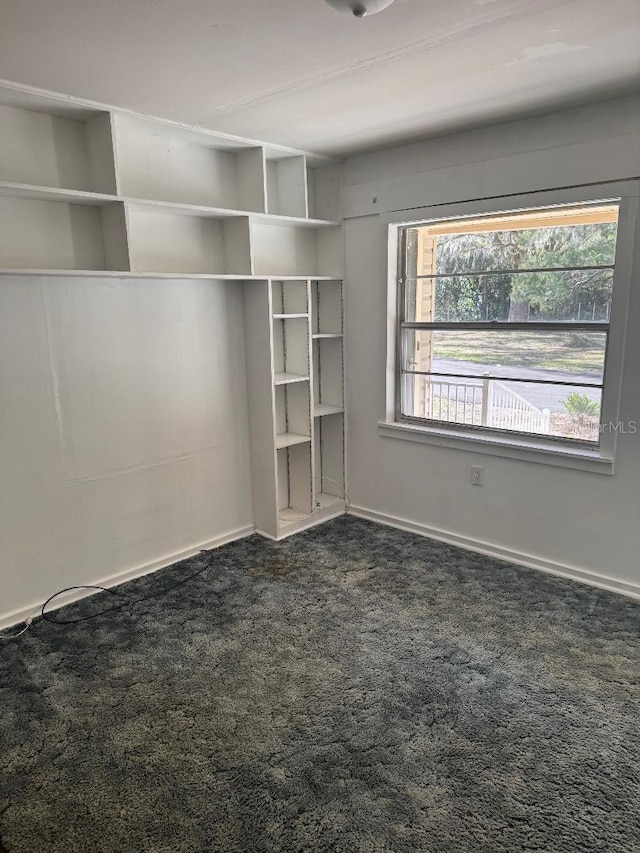 unfurnished bedroom with dark carpet