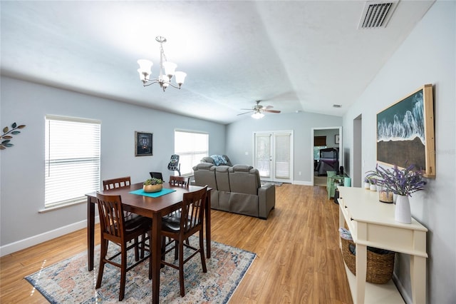 dining area with lofted ceiling, light hardwood / wood-style flooring, and ceiling fan with notable chandelier