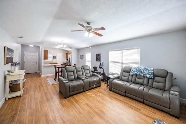 living room featuring ceiling fan with notable chandelier, light hardwood / wood-style floors, and lofted ceiling