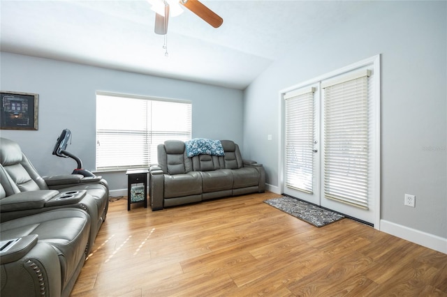 living room with ceiling fan, vaulted ceiling, and light hardwood / wood-style flooring