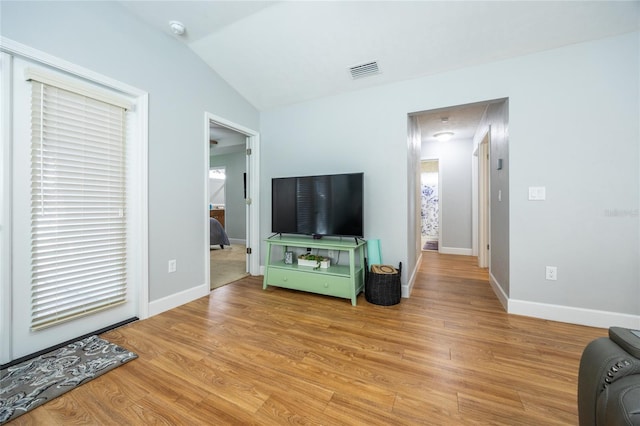 living room featuring light hardwood / wood-style floors and lofted ceiling