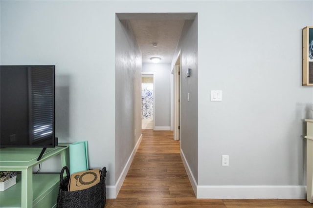 hallway featuring hardwood / wood-style floors and a textured ceiling