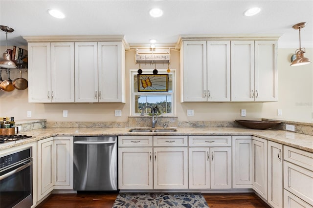 kitchen with light stone countertops, sink, pendant lighting, and appliances with stainless steel finishes