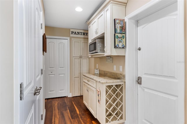 kitchen featuring light stone counters and dark wood-type flooring