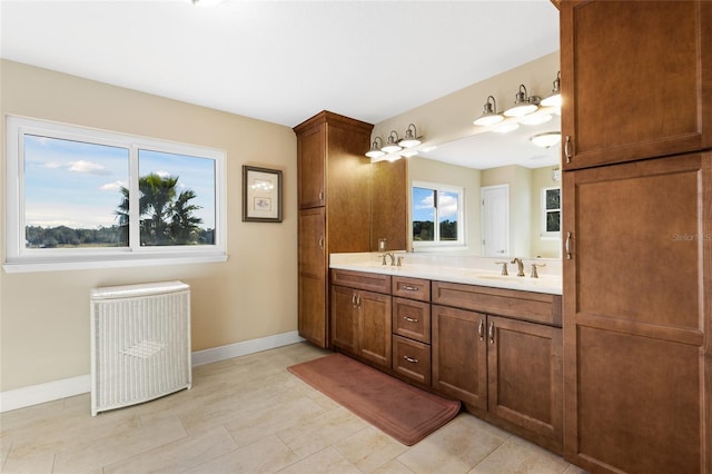 bathroom with tile patterned floors, radiator, a wealth of natural light, and vanity