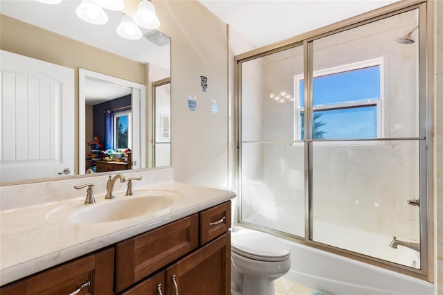 full bathroom with tile patterned floors, vanity, bath / shower combo with glass door, and toilet