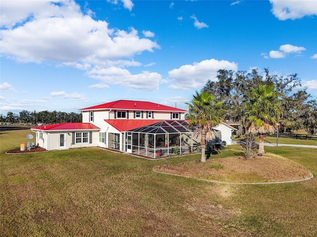 back of house featuring a lawn and a lanai