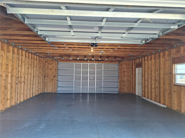 garage with a garage door opener and wooden walls