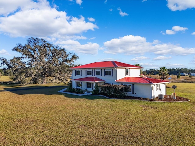 view of front of house with a front yard and central AC