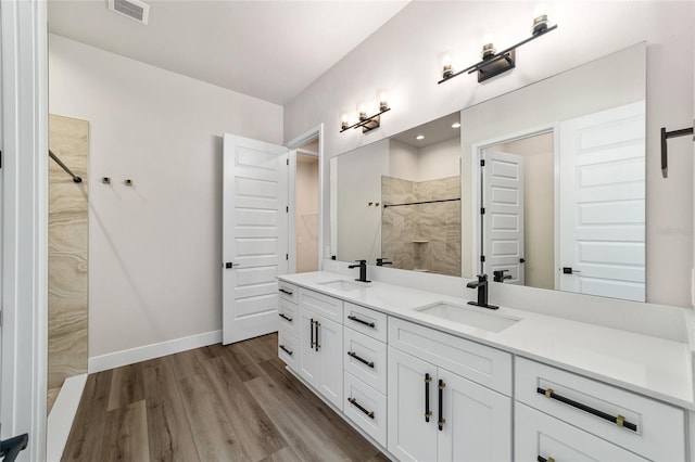 bathroom with a shower, vanity, and hardwood / wood-style flooring