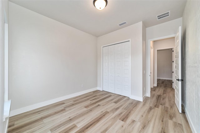 unfurnished bedroom with a closet and light hardwood / wood-style floors