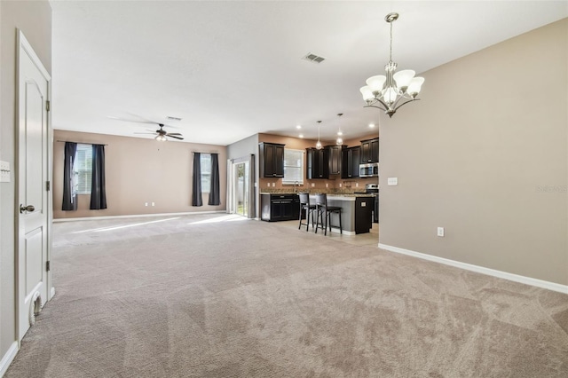 unfurnished living room with light carpet and ceiling fan with notable chandelier