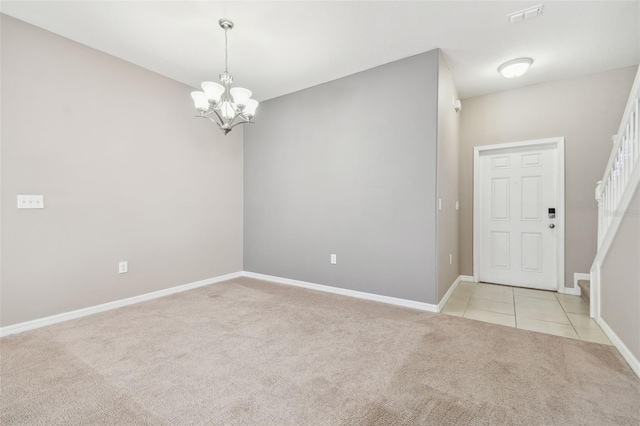 carpeted spare room featuring a notable chandelier