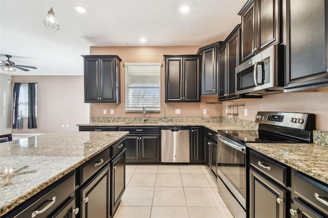 kitchen featuring light stone countertops, appliances with stainless steel finishes, ceiling fan, sink, and light tile patterned floors