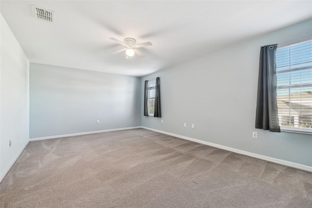 carpeted spare room featuring ceiling fan