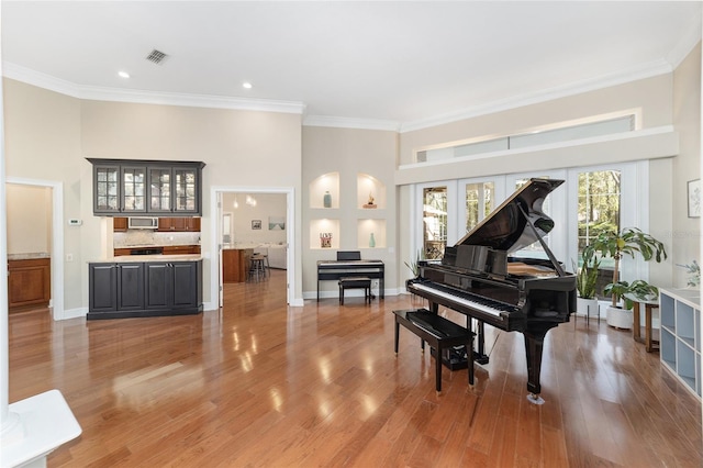 misc room featuring hardwood / wood-style flooring, a high ceiling, and ornamental molding