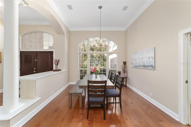 dining space featuring hardwood / wood-style floors, ornamental molding, and a chandelier