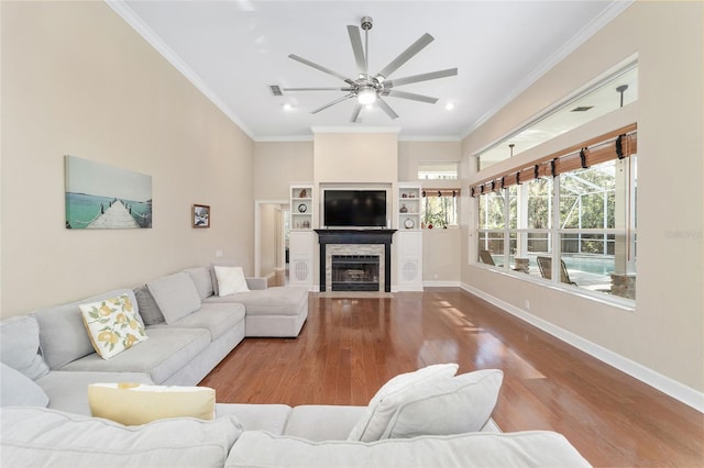 living room with wood-type flooring, ceiling fan, and crown molding