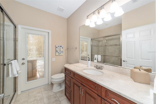 bathroom featuring tile patterned flooring, vanity, toilet, and an enclosed shower