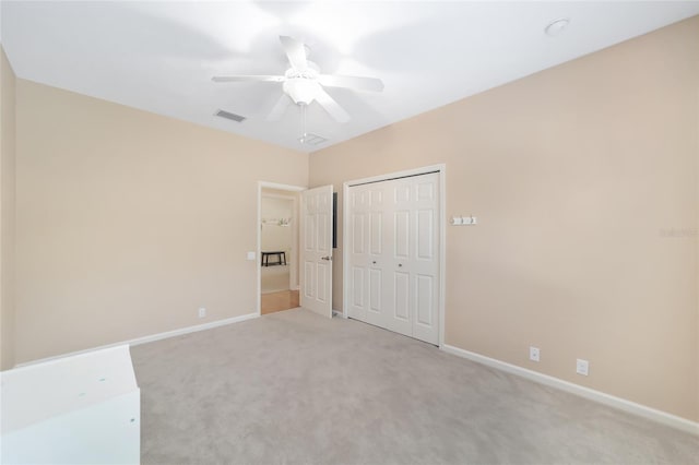 unfurnished bedroom with ceiling fan, light colored carpet, and a closet