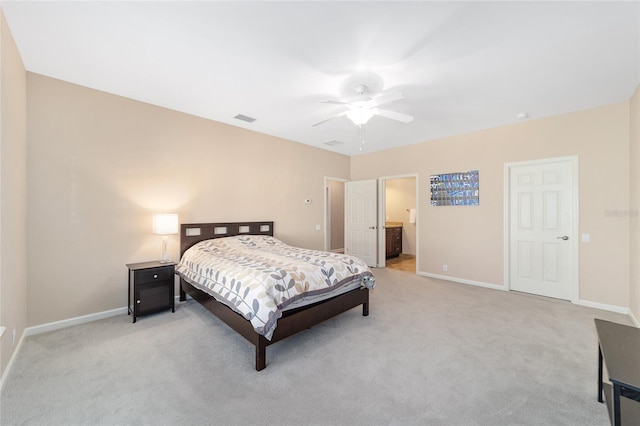 bedroom featuring connected bathroom, ceiling fan, and light colored carpet