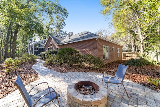 back of property featuring a lanai, an outdoor fire pit, and a patio