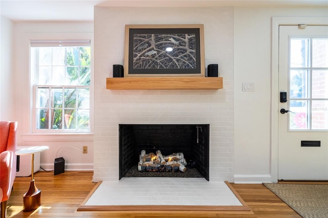 interior details featuring hardwood / wood-style floors and a large fireplace