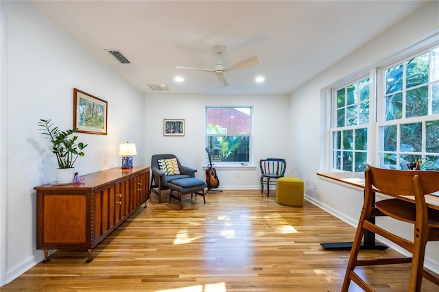 sitting room featuring ceiling fan, light wood-type flooring, and a wealth of natural light