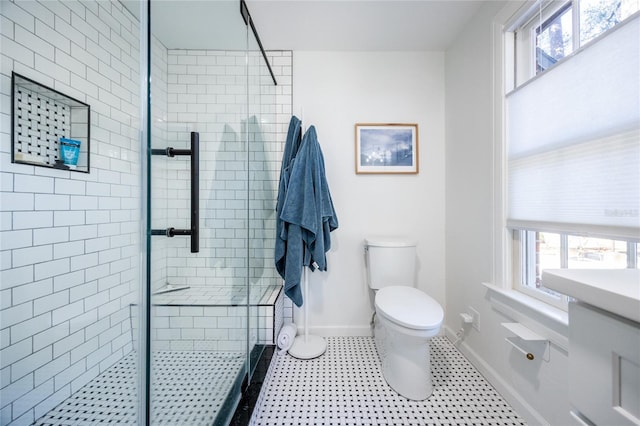 bathroom with plenty of natural light, vanity, a shower with shower door, and toilet