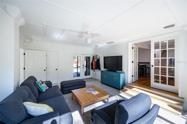 living room featuring ceiling fan and french doors