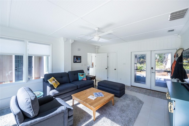 tiled living room featuring ceiling fan and french doors