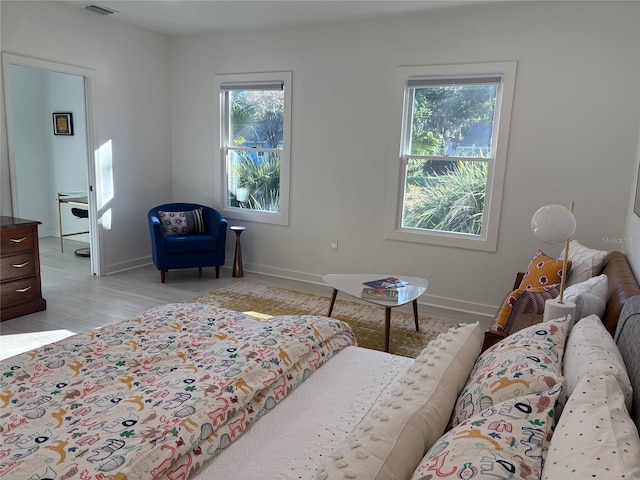 bedroom featuring light wood-type flooring and multiple windows