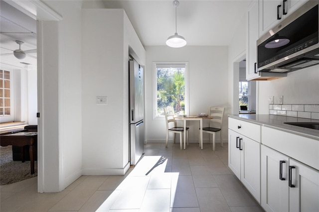 kitchen with white cabinetry, ceiling fan, stainless steel appliances, pendant lighting, and light tile patterned flooring