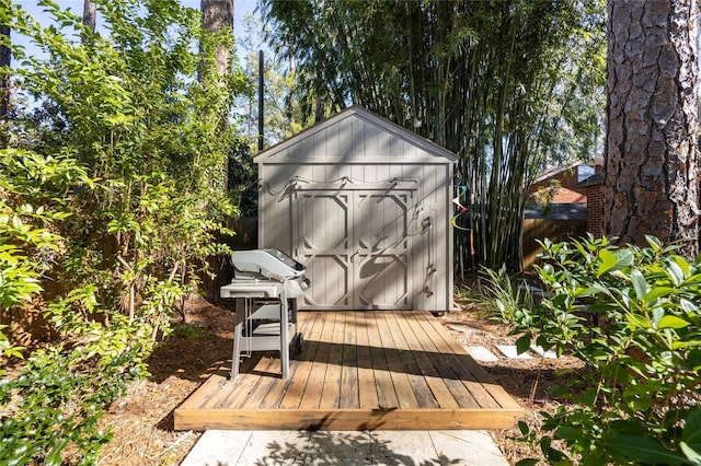 wooden deck featuring a storage unit and grilling area