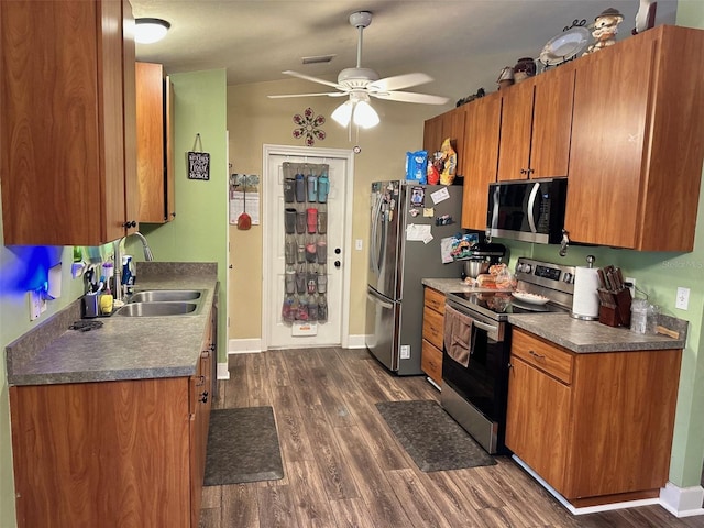 kitchen featuring appliances with stainless steel finishes, dark hardwood / wood-style flooring, ceiling fan, and sink