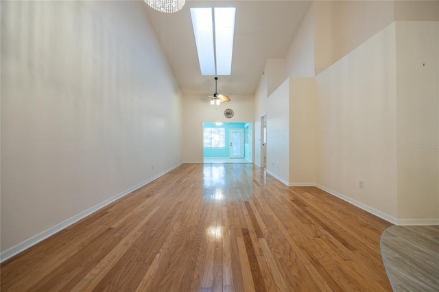 spare room with ceiling fan, high vaulted ceiling, and light wood-type flooring