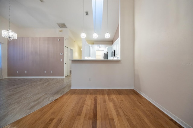 unfurnished living room with light hardwood / wood-style floors and a chandelier