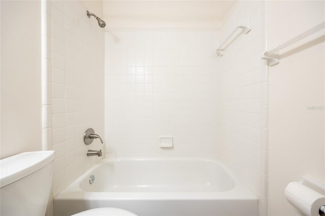 bathroom featuring tiled shower / bath combo and toilet