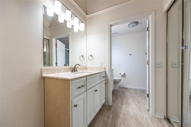 bathroom with vanity, toilet, and crown molding