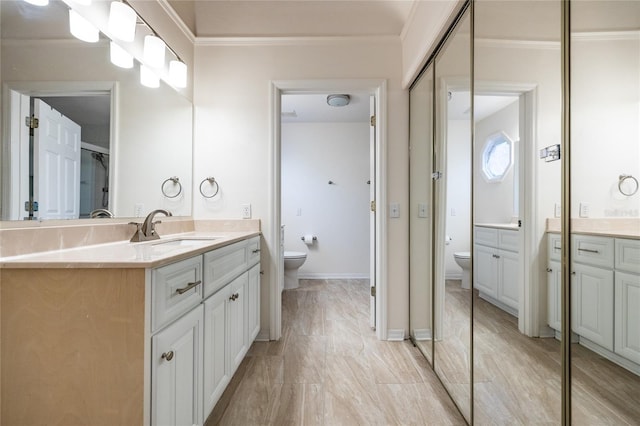 bathroom featuring vanity, toilet, and crown molding