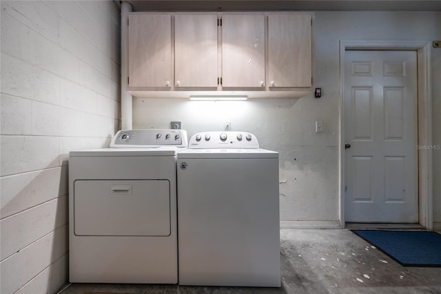 clothes washing area featuring cabinets and washing machine and clothes dryer