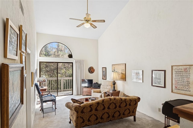 carpeted living room featuring ceiling fan and high vaulted ceiling