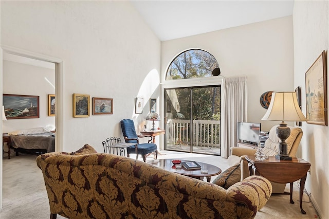 living room with light colored carpet and high vaulted ceiling