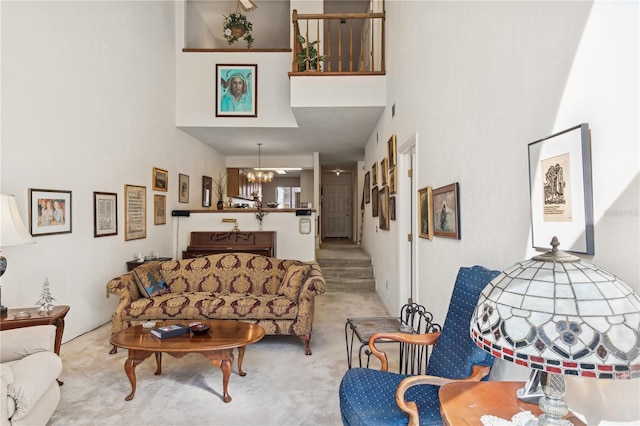 carpeted living room with a high ceiling and a chandelier