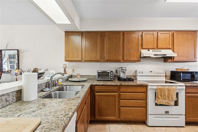 kitchen featuring light stone countertops, sink, light tile patterned floors, and white appliances