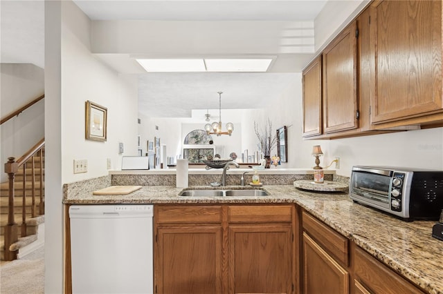 kitchen featuring light stone countertops, dishwasher, sink, light colored carpet, and a chandelier